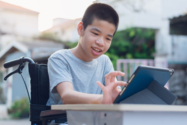 Disabled child on wheelchair happy time to use a tablet in the house, Study and Work at home for safety from covid 19, Life in the education age of special need kid, Happy disability boy concept.